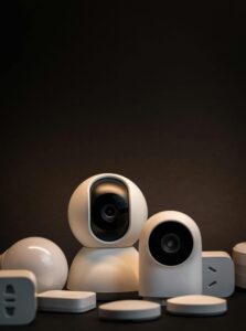 Close-up of modern white security cameras and smart home devices with dark background.
